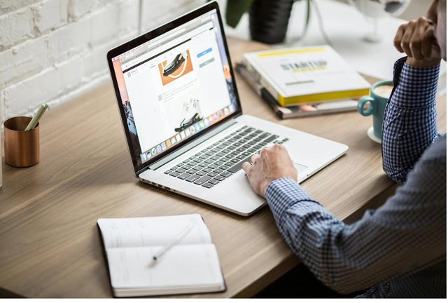 A product manager sketching an idea beside her laptop