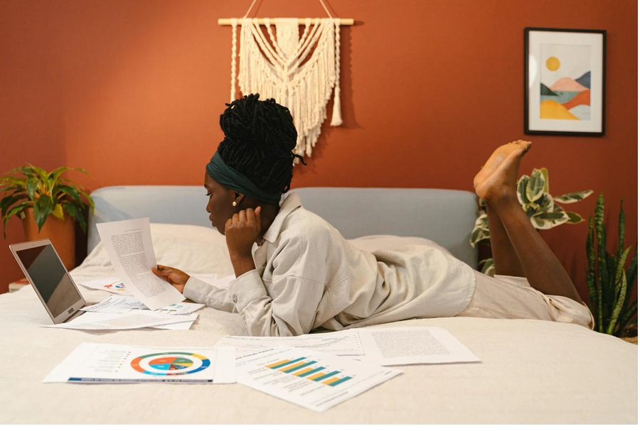 A learner studying at home with her notes spread out