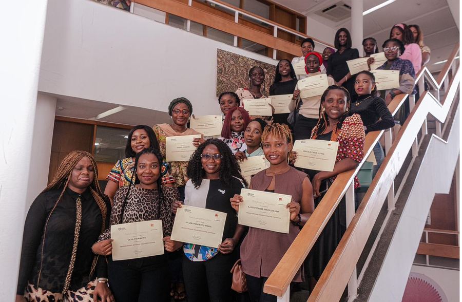 Graduates holding up their certificates on the stairs