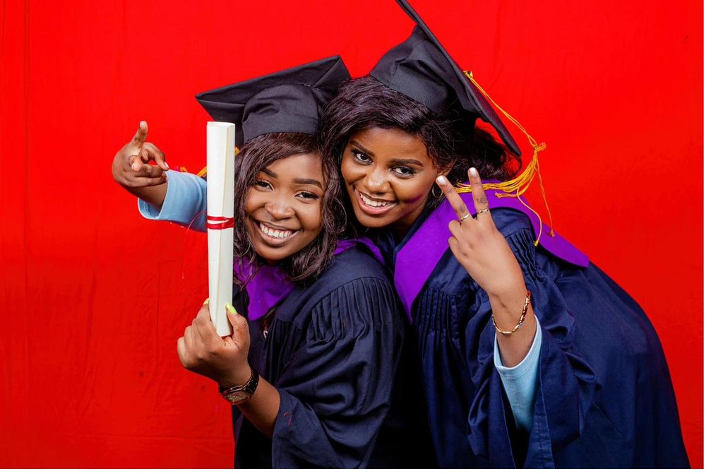 Two graduates celebrating in cap and gown